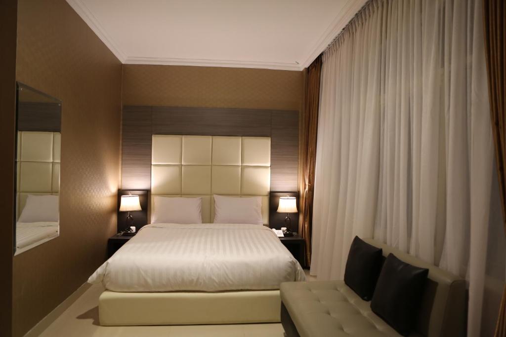 a hotel room with a bed and a couch at Hotel 55 in Jakarta
