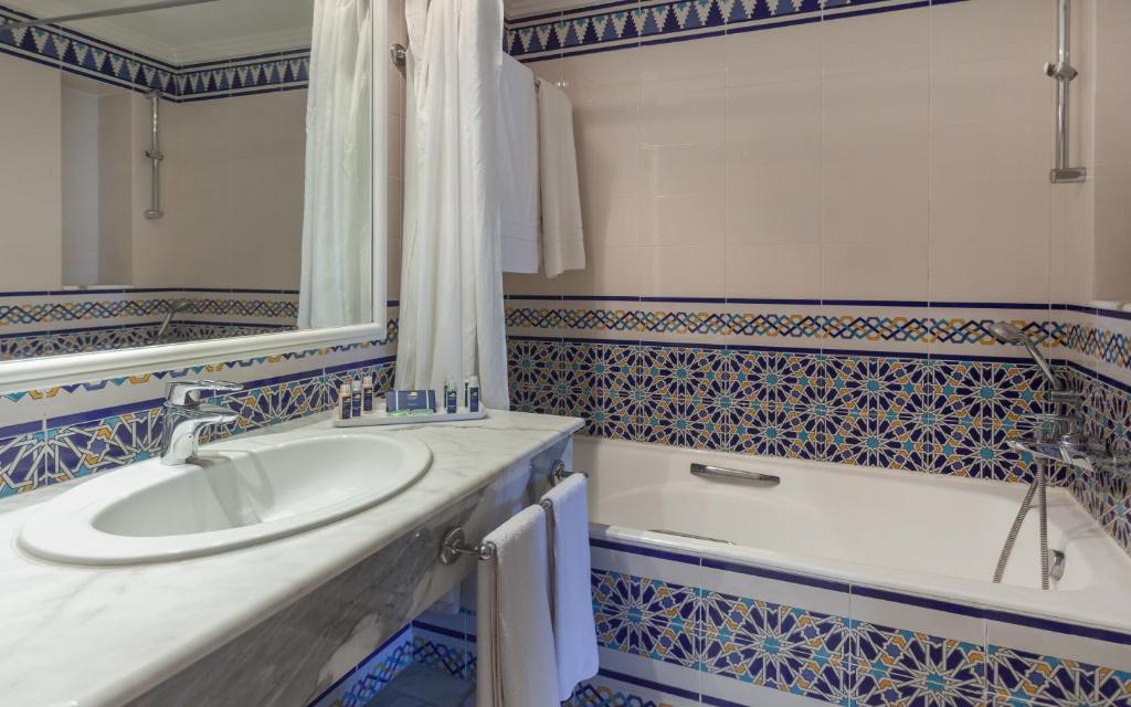 a bathroom with a sink and a bath tub at OCEANA Hotel & Spa in Hammamet