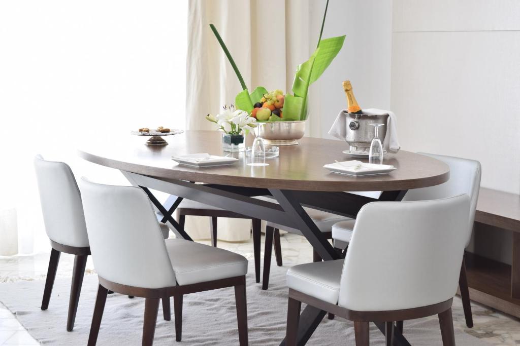 a dining room table with white chairs and a wooden table at OCEANA Hotel & Spa in Hammamet