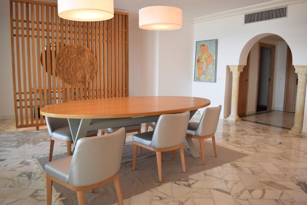 a dining room with a wooden table and chairs at OCEANA Hotel & Spa in Hammamet