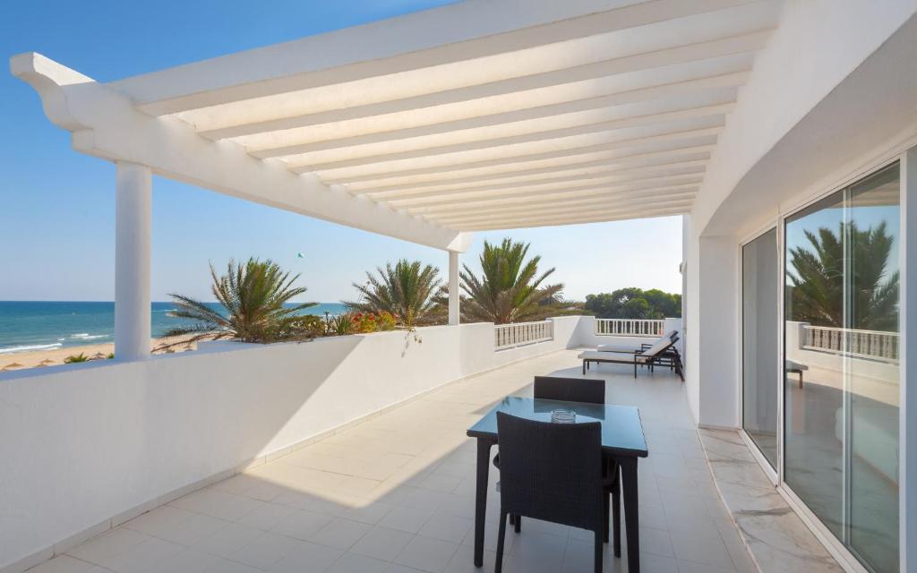 a balcony with a table and chairs and the ocean at OCEANA Hotel & Spa in Hammamet