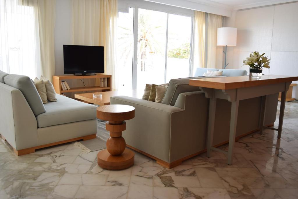 a living room with a couch and a table and a tv at OCEANA Hotel & Spa in Hammamet