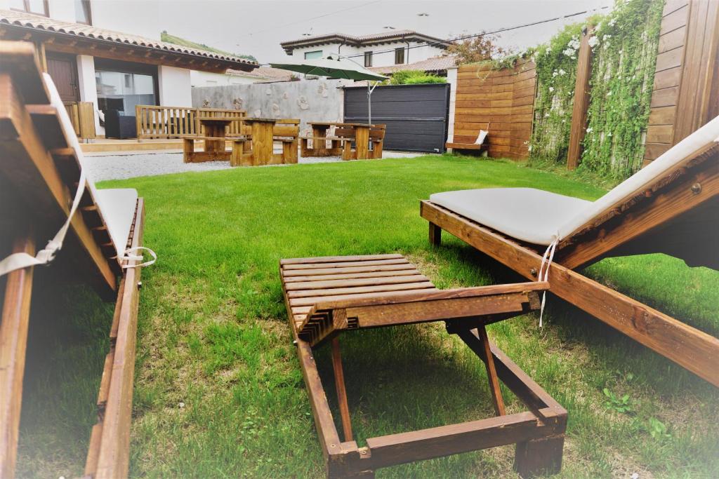 un patio trasero con una silla, una mesa y un césped en Apartamentos La Playina, en Llanes