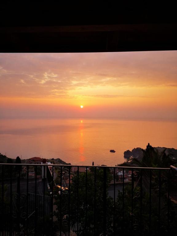 a view of the ocean at sunset from a balcony at Villa Sofia in Taormina