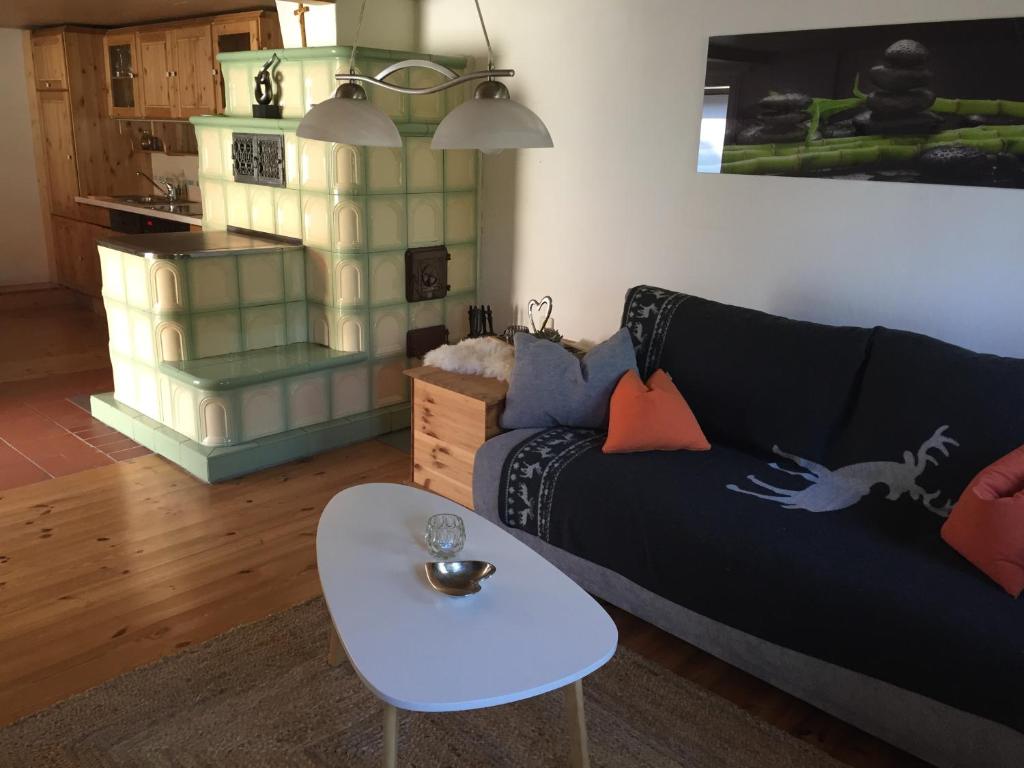 a living room with a black couch and a table at Ferienhaus Perwolff in Eisenberg an der Pinka