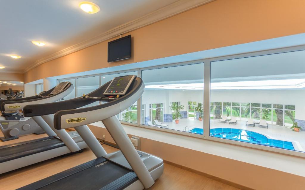 a gym with a treadmill and a swimming pool at OCEANA Hotel & Spa in Hammamet