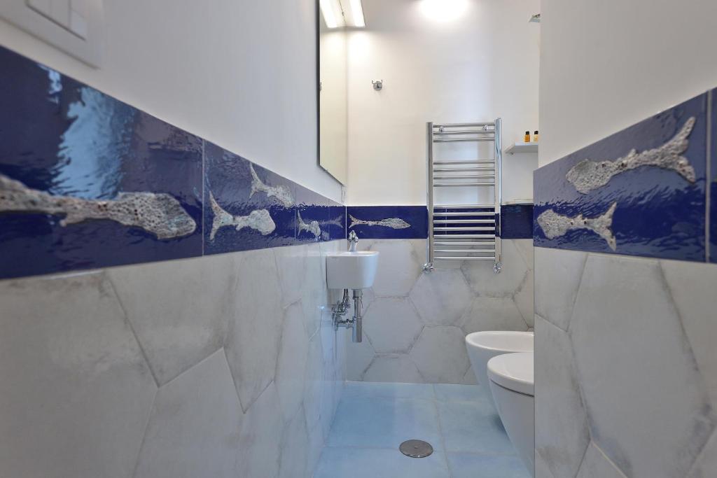 a bathroom with a white toilet and a blue wall at Casa Amorino in Minori