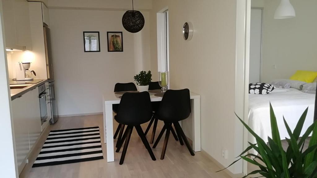 een keuken met een tafel en stoelen in een kamer bij Feels like Home City Holvi in Jyväskylä