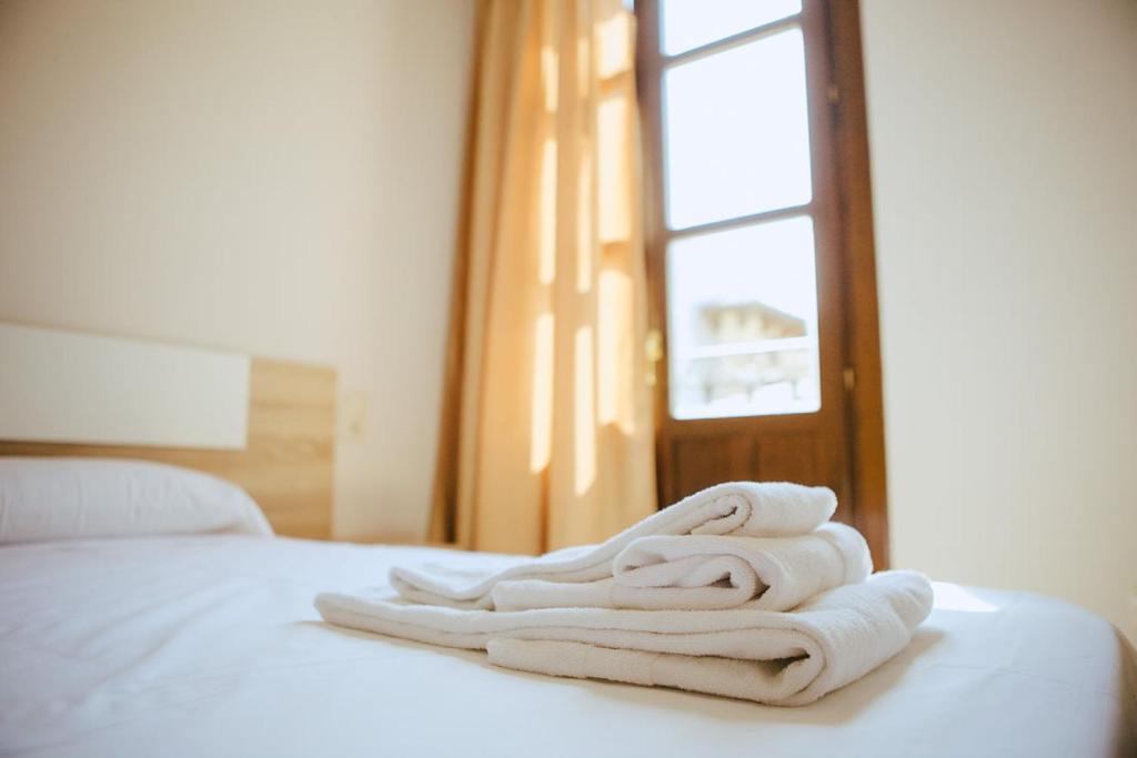 una pila de toallas sentadas encima de una cama en Apartamentos Ducay, en Olite