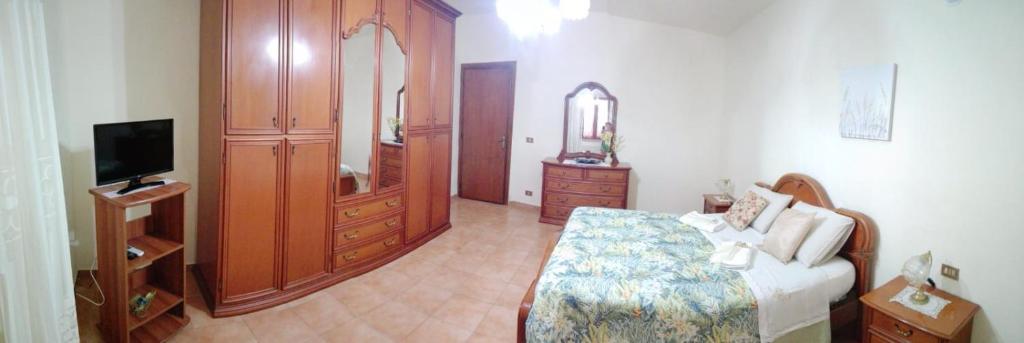 1 dormitorio con 1 cama, vestidor y TV en A Casa Mia, en Cascina