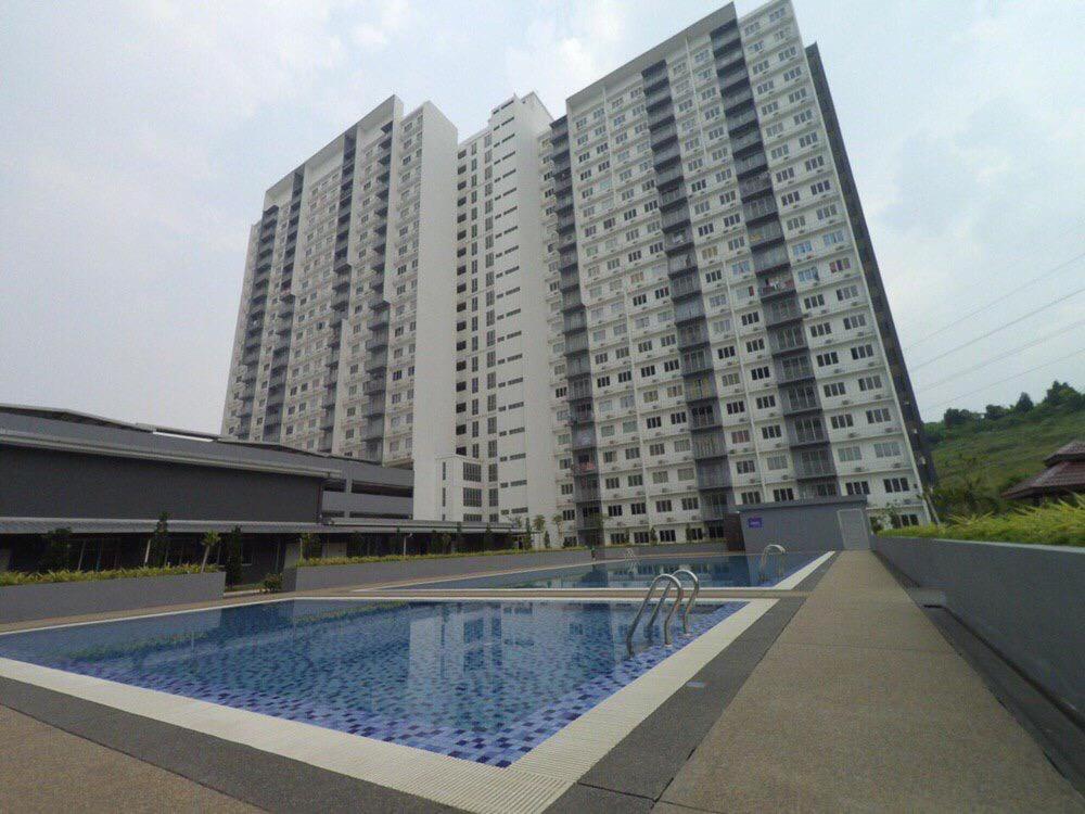 um grande edifício de apartamentos com uma piscina em frente em Wan Homestay Putra Impian em Kajang