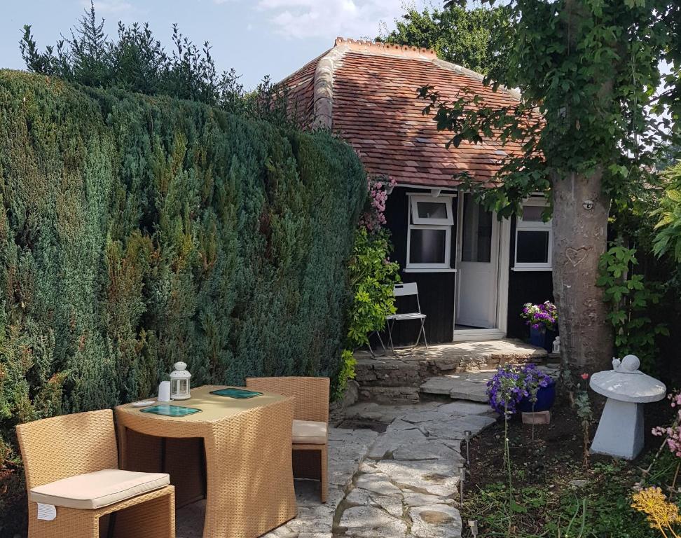 a garden with a table and chairs and a house at Nether Oslands in Lower Swanwick