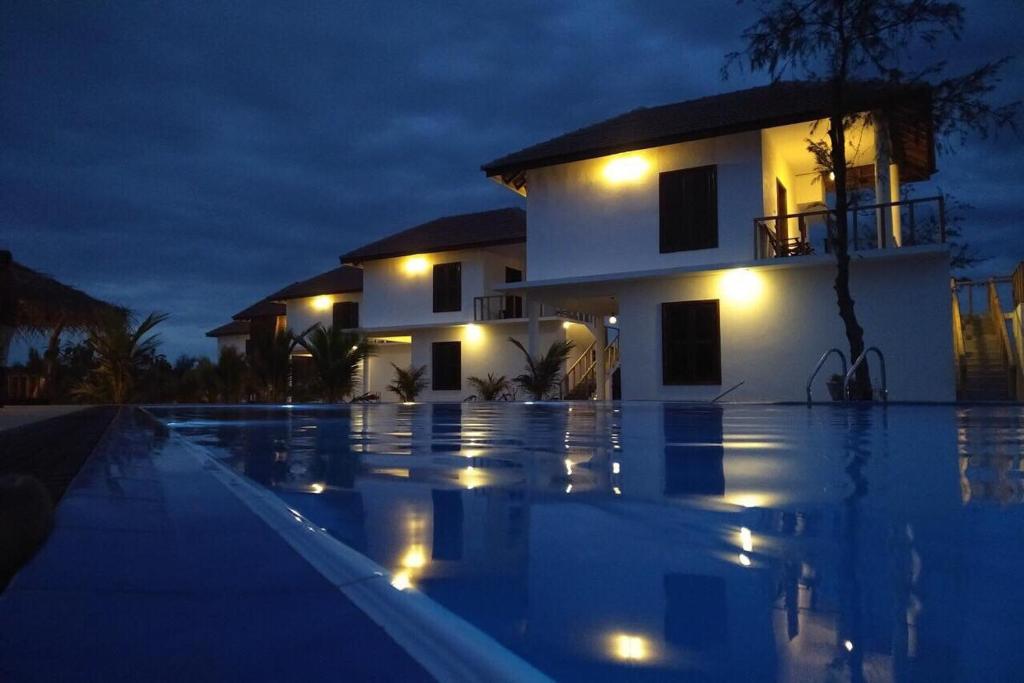 uma villa com piscina à noite em Whisky Point Surf Cabana em Baía de Arugam