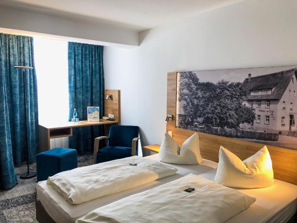 Cette chambre comprend deux lits et un bureau. dans l'établissement Hotel zum Engel, à Mespelbrunn