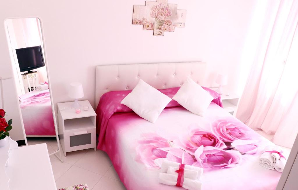 a bedroom with a pink bed with pink roses on it at Anchor and Rose in Salerno