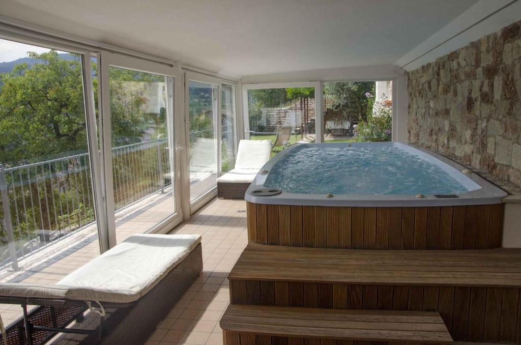 a jacuzzi tub in a room with a balcony at Villetta Glicine in Brentonico