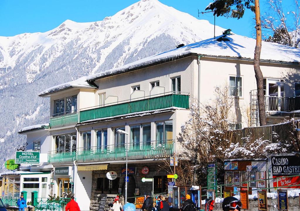 a building on a street with a snow covered mountain at Hotel Goethehof in Bad Gastein
