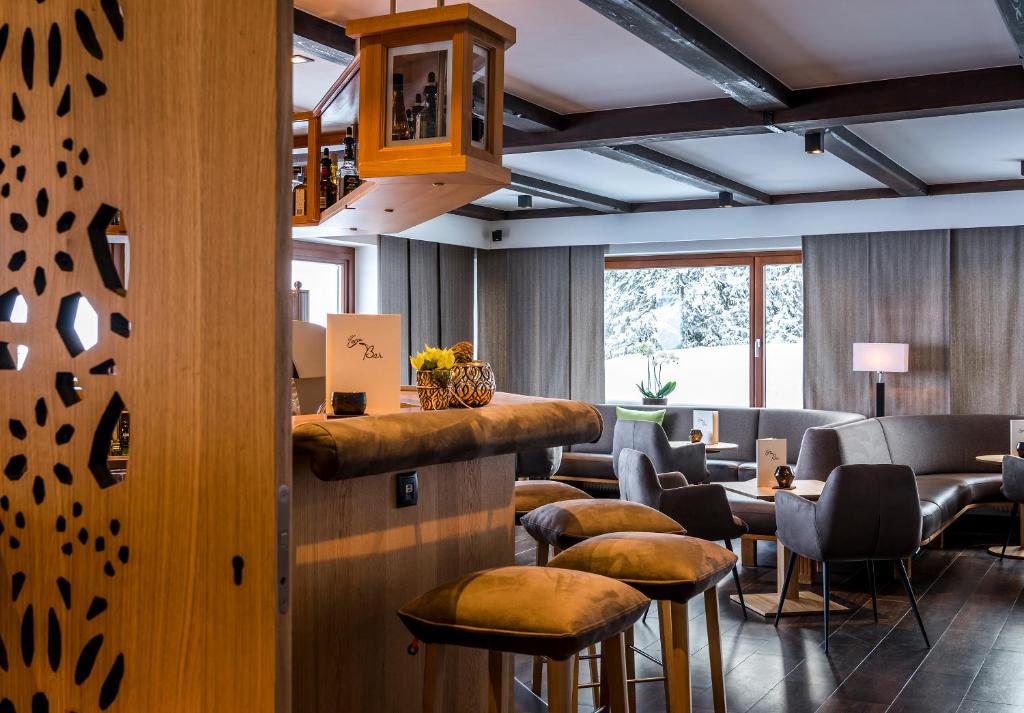 un bar en un restaurante con taburetes y mesas en Cresta.Alpin.Sport.Hotel, en Lech am Arlberg