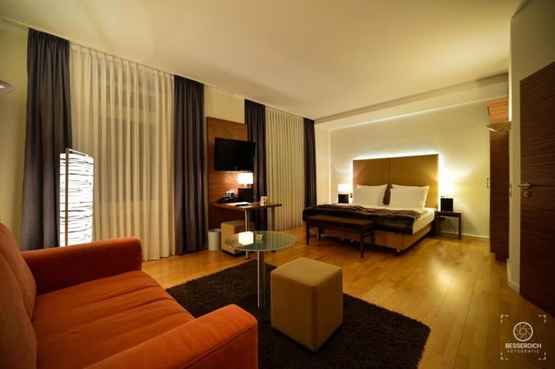 ein Hotelzimmer mit einem Bett und einem Sofa in der Unterkunft Domicil Leidinger in Saarbrücken