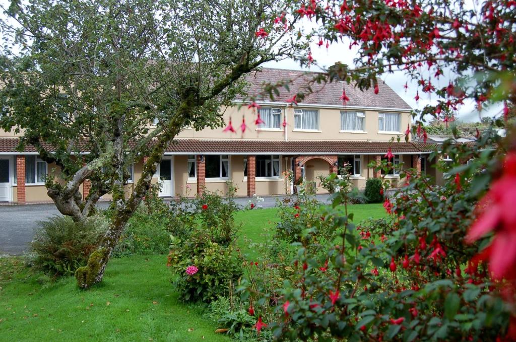 una casa grande con flores delante en The Gardens B&B, en Killarney