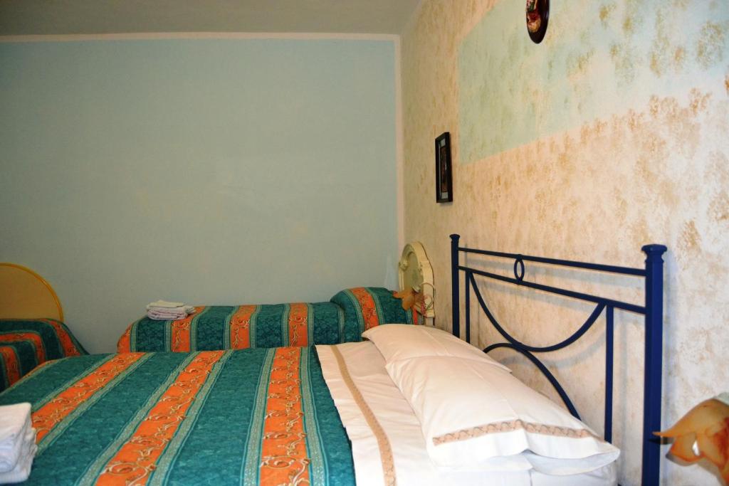 1 dormitorio con 2 camas con sábanas verdes y naranjas en Appartamento bello e comodo, en Aritzo