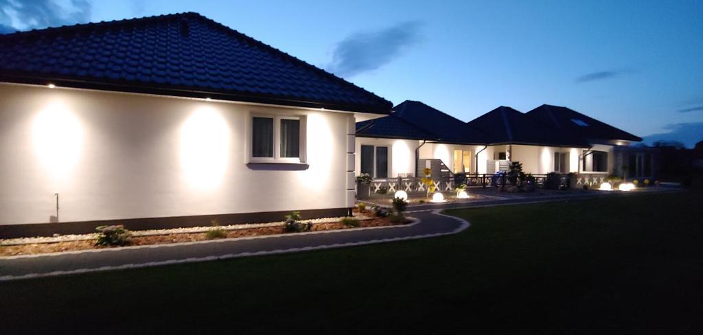 un par de casas con mesas y sombrillas por la noche en Apartamenty Dżemejra - Jumeirah en Darłowo