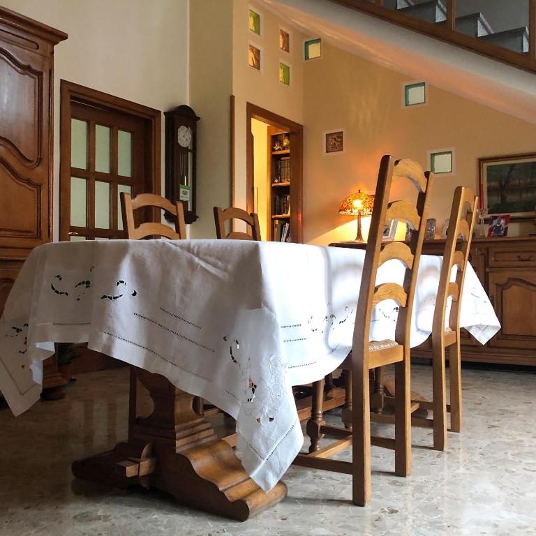 stół i krzesła z białą tkaniną w obiekcie Domus Birdi w mieście Orroli