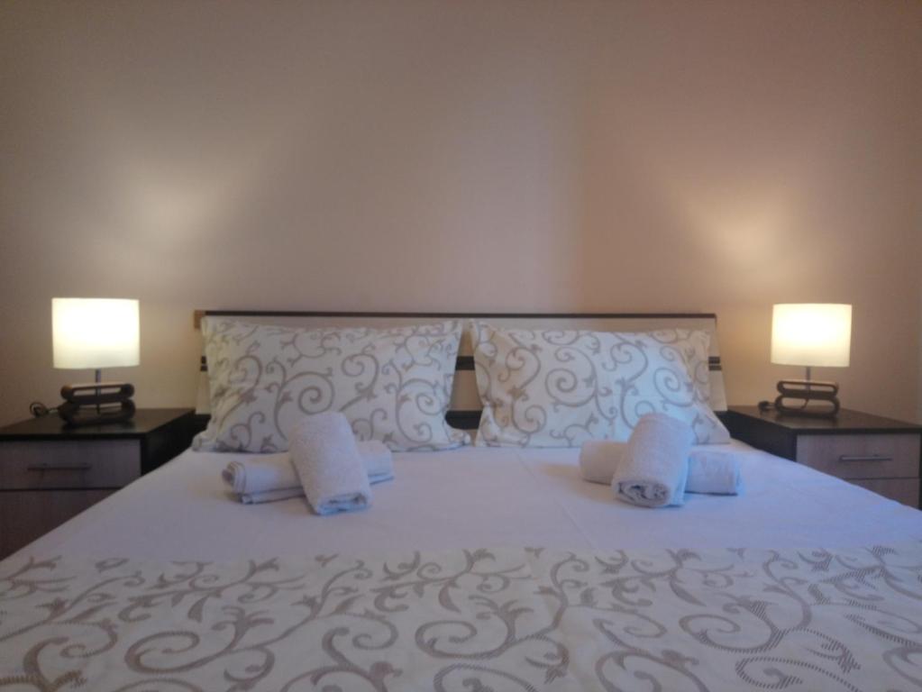 ein Schlafzimmer mit einem großen weißen Bett mit zwei Lampen in der Unterkunft Bohemian Rhapsody NBG in Belgrad