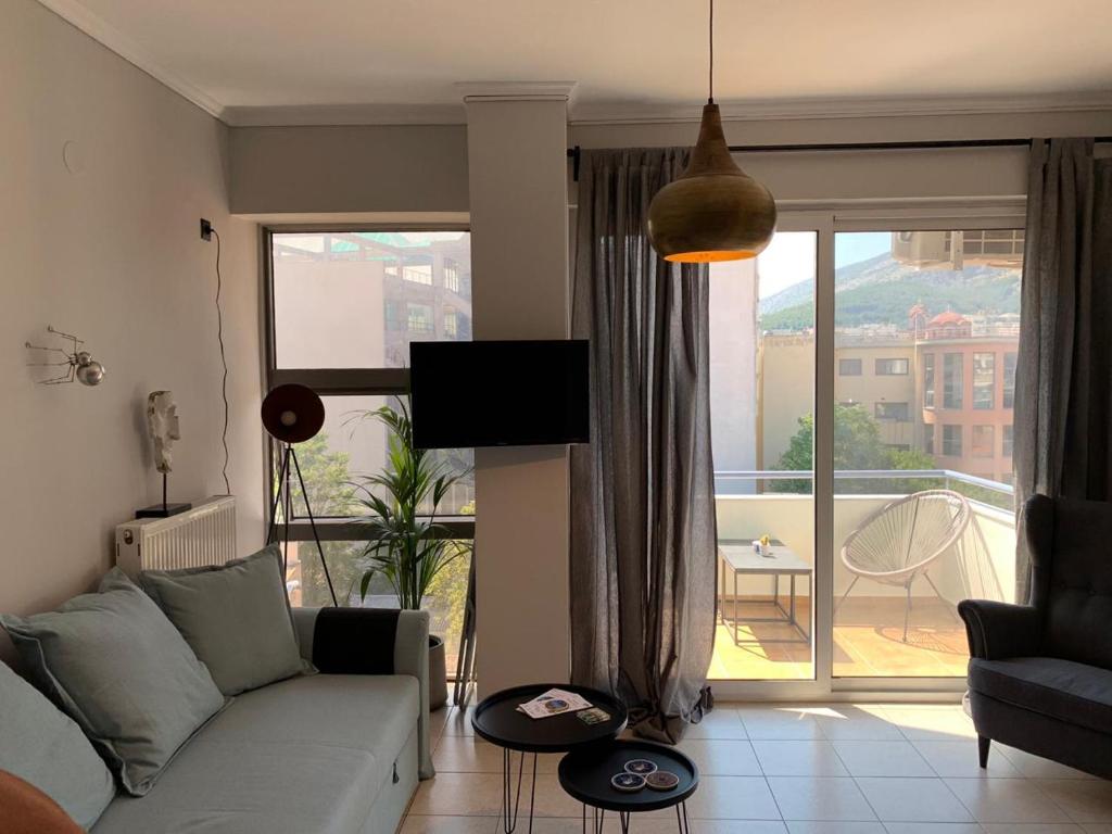 a living room with a couch and a large window at Main Square Flat - LUXURY APARTMENTS XANTHI LAX in Xanthi