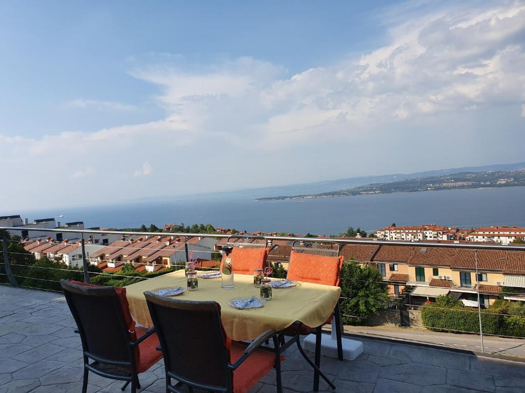 a table and chairs on a patio with a view of the water at Vila Maris in Koper