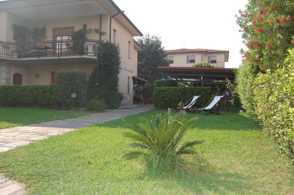 a house with a yard with a palm plant at Affittacamere Loretta in San Giuliano Terme