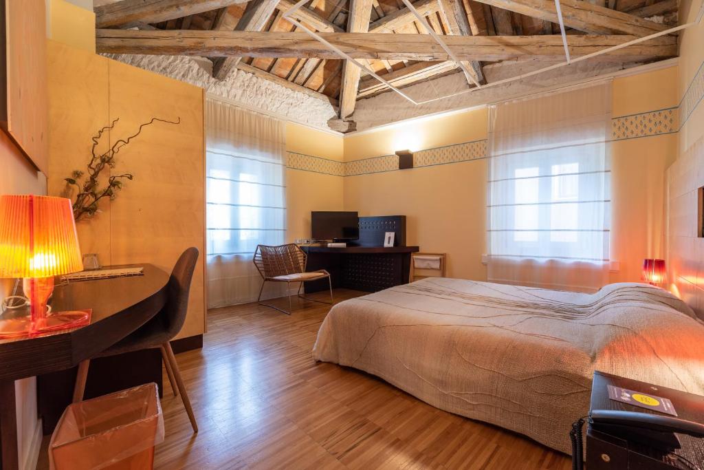 1 dormitorio con 1 cama y escritorio con ordenador en Hotel Suite Inn en Udine