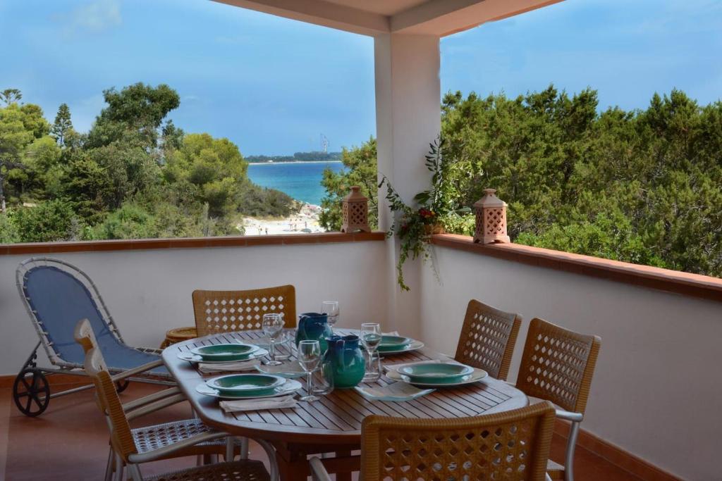 een tafel op een balkon met uitzicht op de oceaan bij Villa Orrì in Tortolì