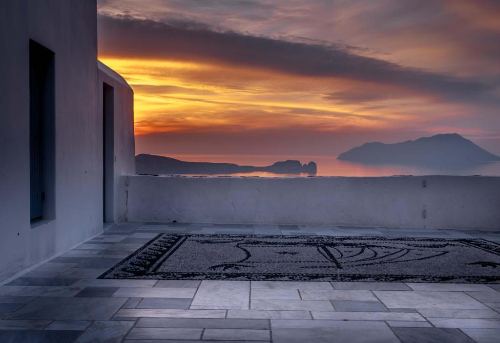 a sunset from a building with a view of the ocean at Sunset Nest in Plaka Milou