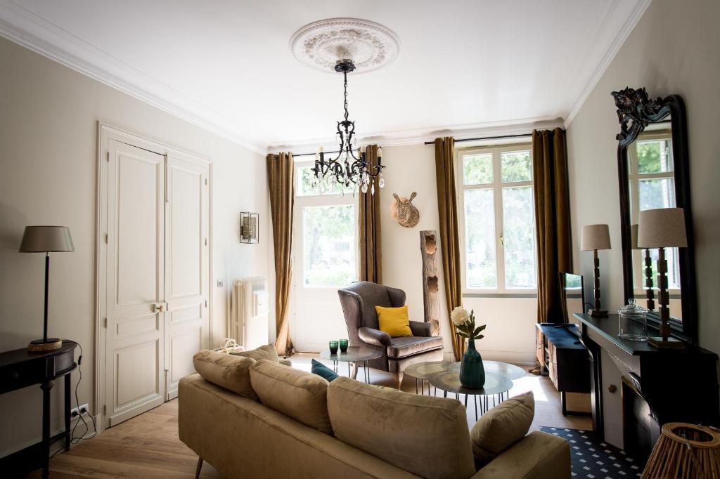 ein Wohnzimmer mit einem Sofa und einem Tisch in der Unterkunft La Suite d'Elisabeth in Sarlat-la-Canéda