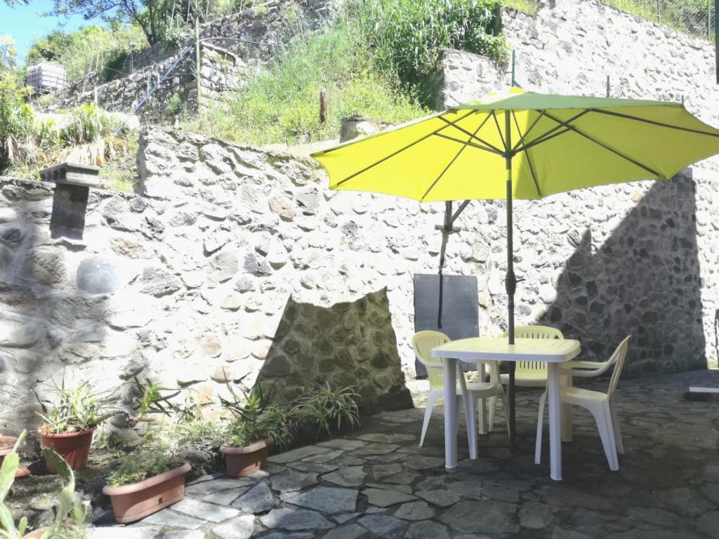a yellow umbrella sitting on a table with chairs at Gianna's cosy apartment in Monterosso al Mare