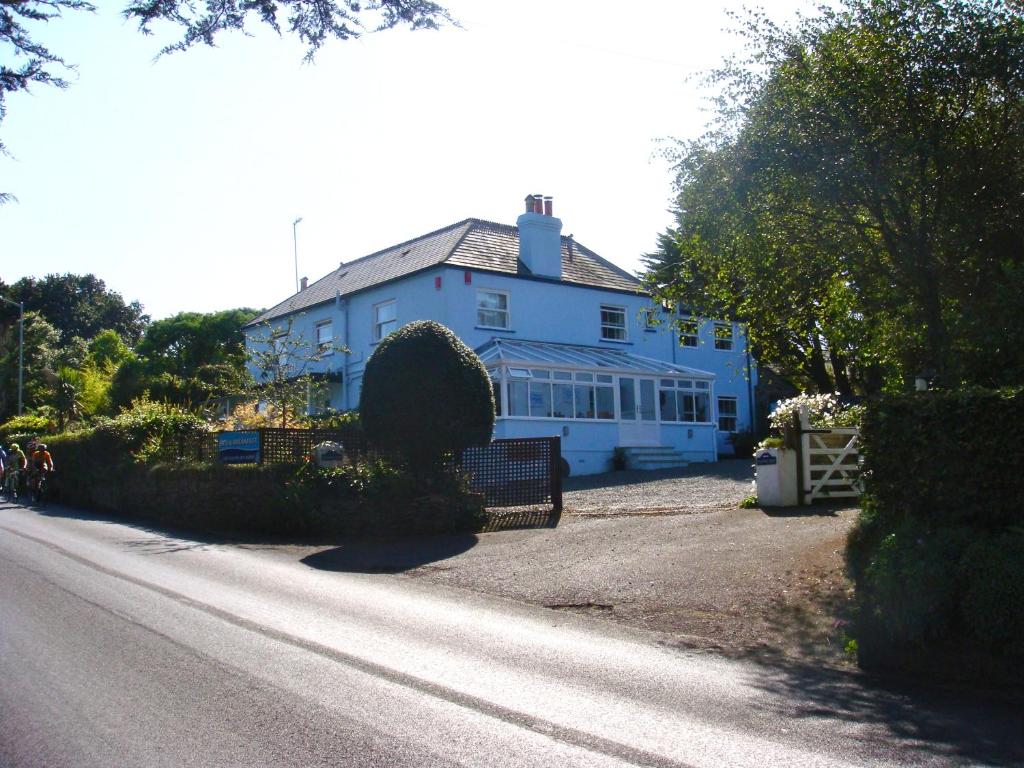 une maison bleue assise sur le côté d'une route dans l'établissement Channel View Guest House, à Stoke Fleming