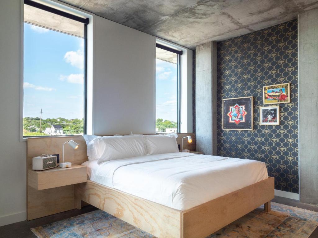 1 dormitorio con 1 cama grande y ventana en ARRIVE Austin en Austin