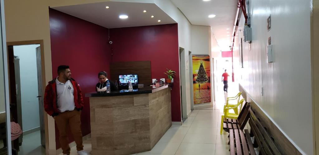 a man standing at a bar in a restaurant at Hotel Luz do Sol in Aparecida