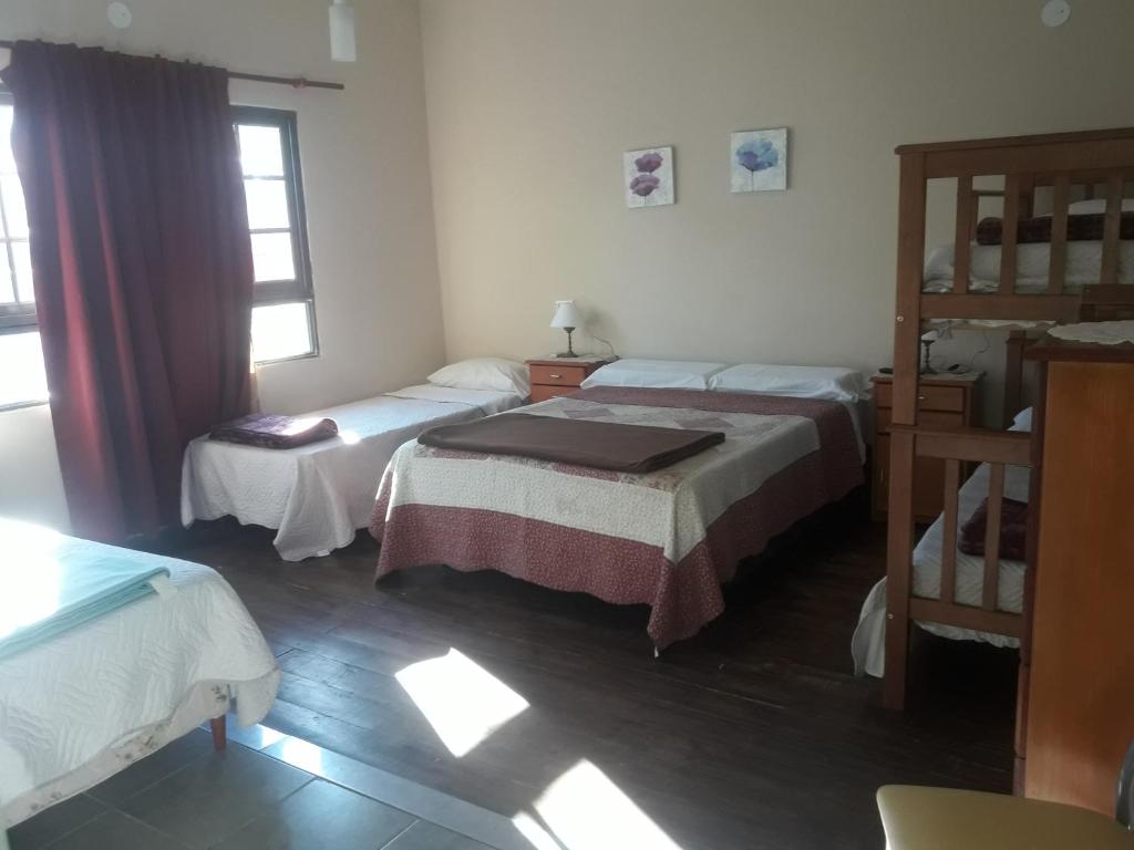 a room with two beds and a bunk bed at Departamentos del centro in Villa Mercedes