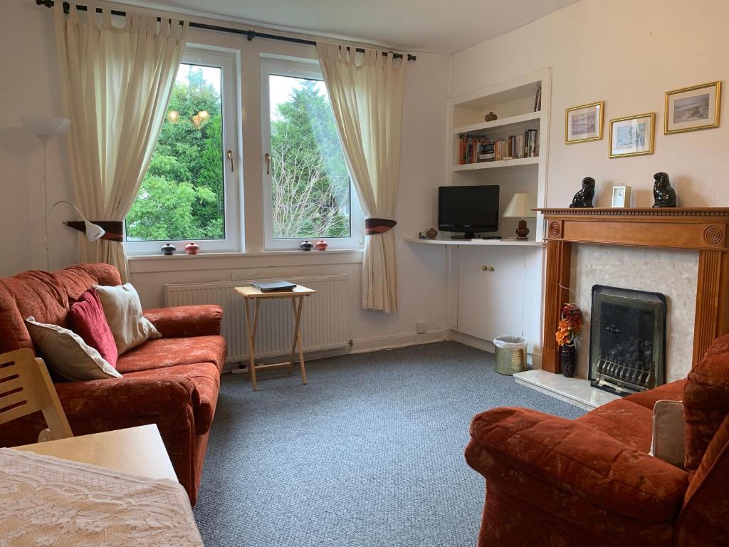 a living room with two couches and a fireplace at Haig Apartments in Kirkcaldy