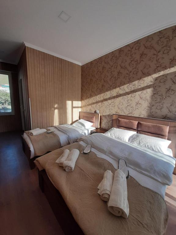 Dos camas en una habitación de hotel con toallas. en Sky Star en Kazbegi
