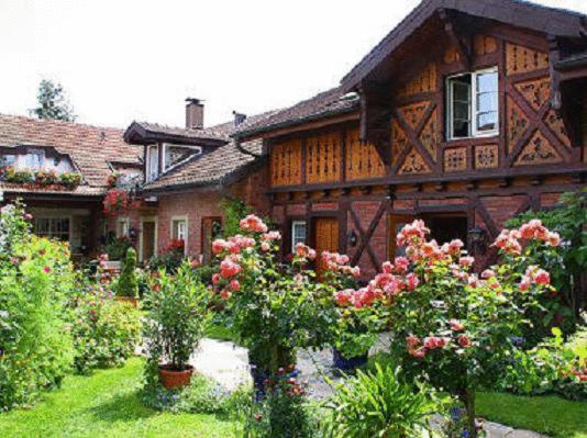 een huis met een bos bloemen ervoor bij Hotel zur Krone in Auggen