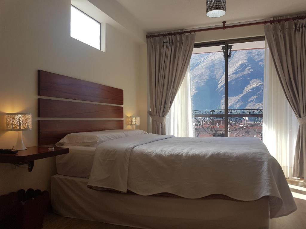 1 dormitorio con cama y ventana grande en Hotel La Posada de Francisca, en Písac