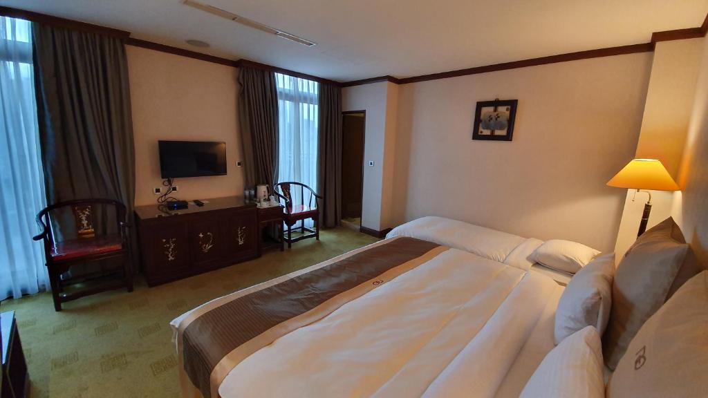 Postel nebo postele na pokoji v ubytování Rich Garden Hotel