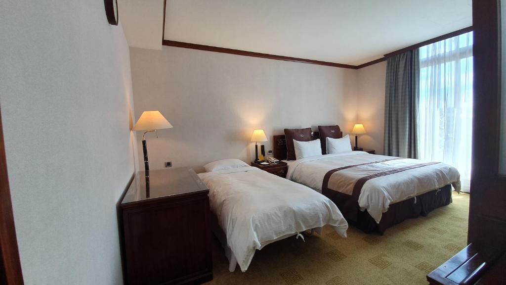 Postel nebo postele na pokoji v ubytování Rich Garden Hotel