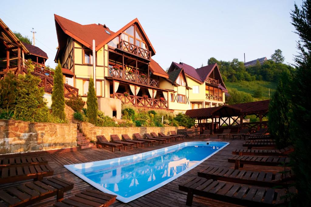 un hotel con piscina di fronte a un edificio di 12 Місяців-Травень, басейн з підігрівом a Slavske