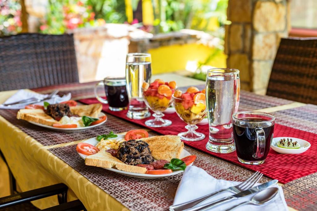 a table with plates of food and glasses of soda at La Terraza Guest House B&B in Grecia