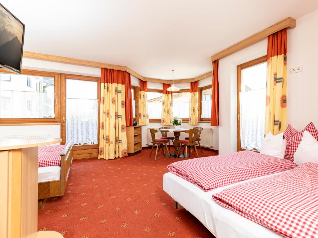 a hotel room with two beds and a table at Tramberger Apartments in Reith im Alpbachtal
