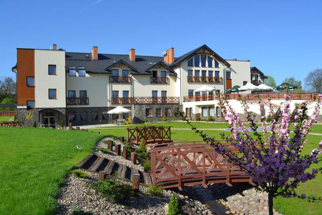 a wooden bench sits in front of a house at Borowinowy Zdrój Hotel Wellness Spa & Conference in Supraśl